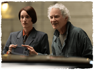 Woman looking bewildered, older man sat nexct to her looking happy