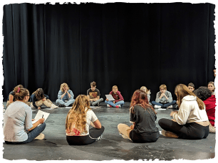 Group of young people sat on floor in circle
