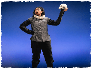 Ana ctor wearing shakespearean clothes and holding a skull