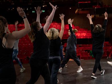 A group of teachers participate in a physical theatre workshop