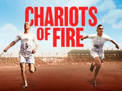 2 athletes in all white running, big crowd behind