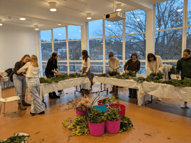 Lots of people round table wreath making
